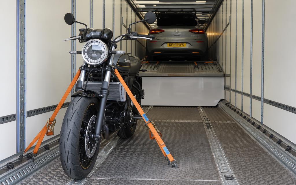 Bike and car strapped inside an enclosed vehicle carrier
